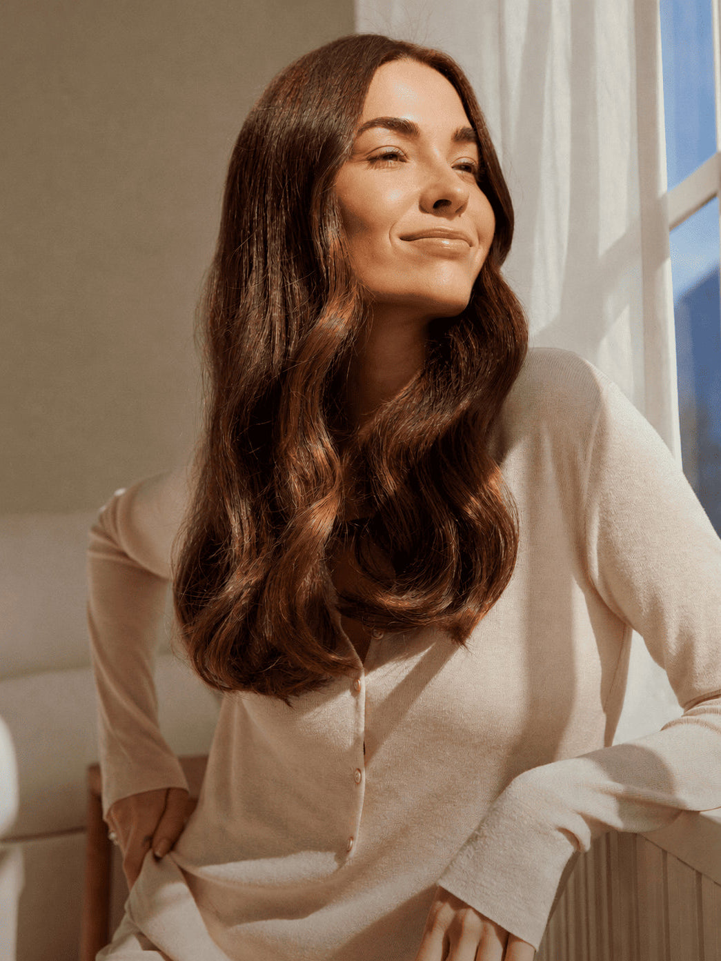 Femme confiante avec de beaux cheveux dans une ambiance douce